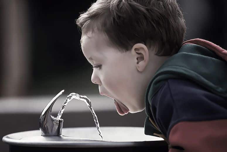 kid drinking water from fountain